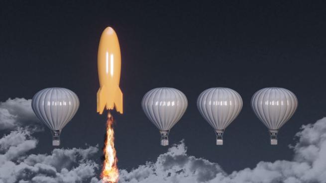 Orange rocket ship next to white hot air balloon
